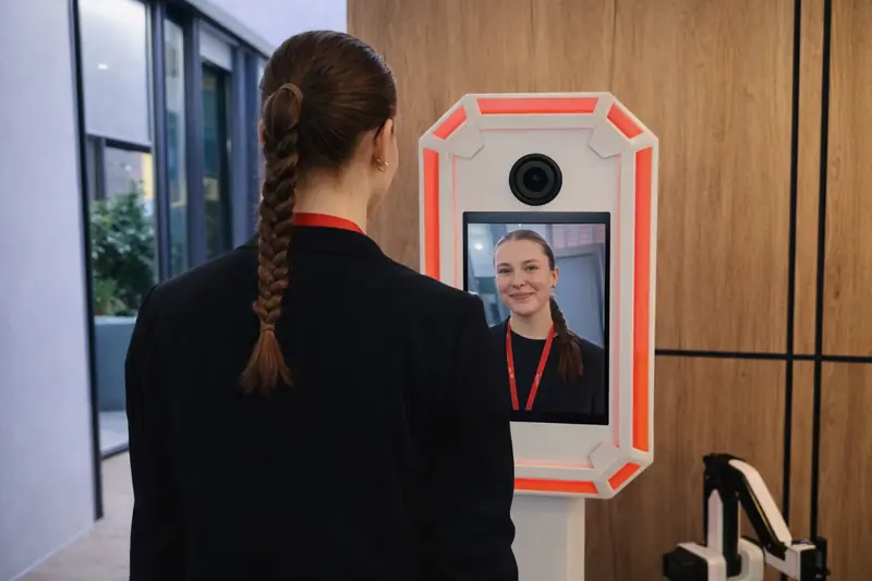 Гость фотографируется на фотостанции для скетчбота